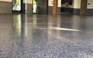 Beautiful high-gloss epoxy and polyaspartic full-flake flooring applied to a large outdoor space.