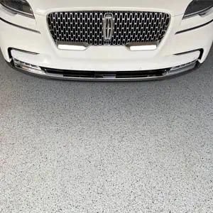 White Ford Lincoln proudly parked on a gray full-flake epoxy and polyaspartic-coated garage floor.